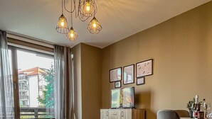 Ett modernt hotellrum med en säng, en soffa, ett skrivbord med en TV och en matplats.