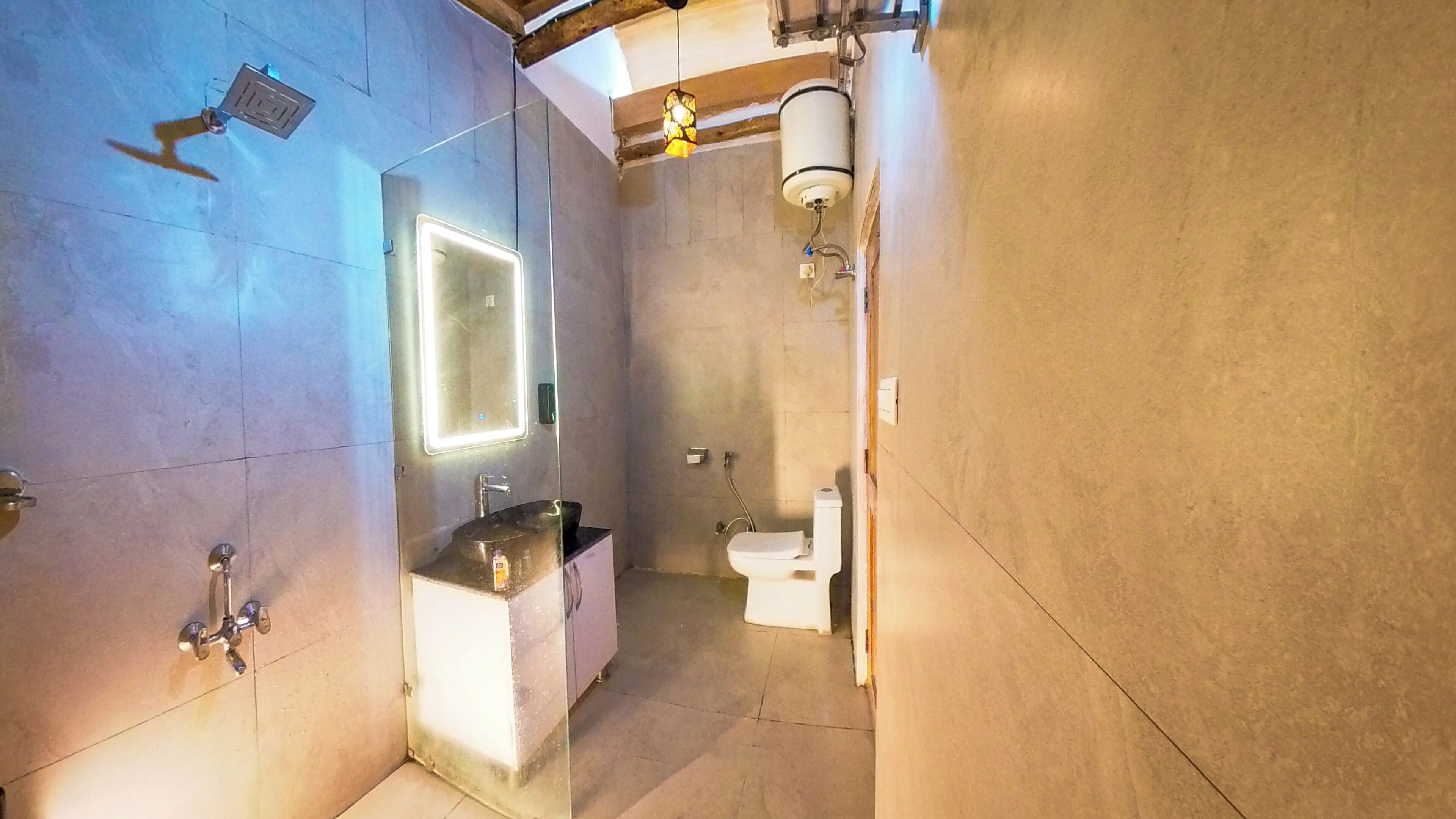 A modern bathroom with a large mirror, a sink, a toilet, and a shower.
