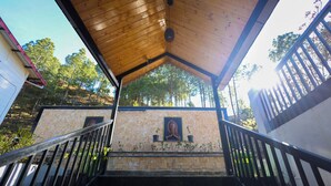 A covered staircase leading to a building with a tiled wall and a framed picture. - Hushvan Resorts (Pauri)