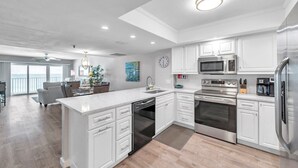 Una cocina moderna con armarios blancos, electrodomésticos de acero inoxidable y una isla grande.