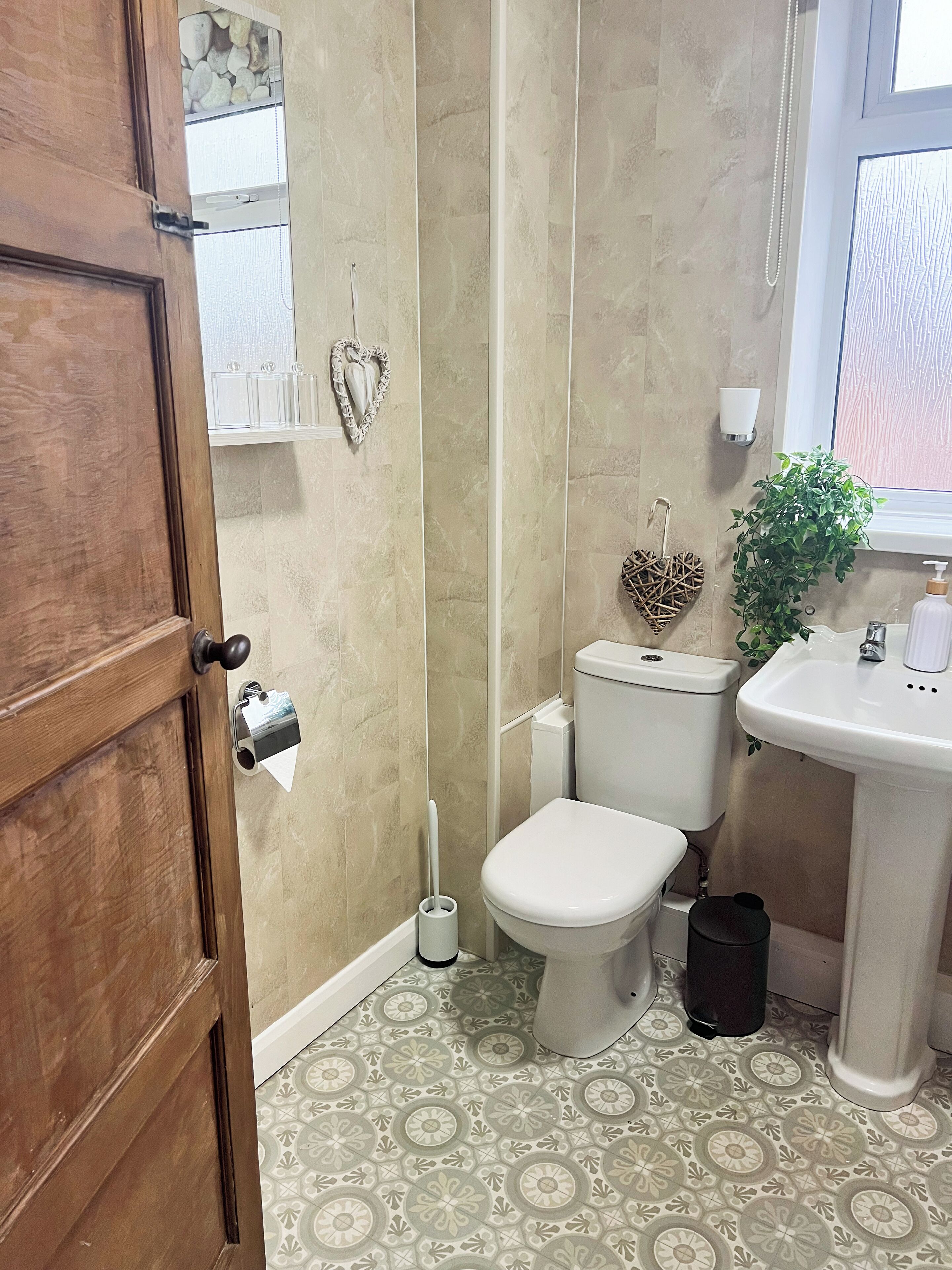 Une salle de bain comprenant des toilettes, un lavabo et un espace douche.