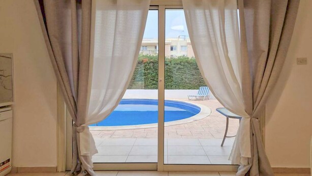 Una stanza con una porta scorrevole in vetro che dà su una zona piscina.