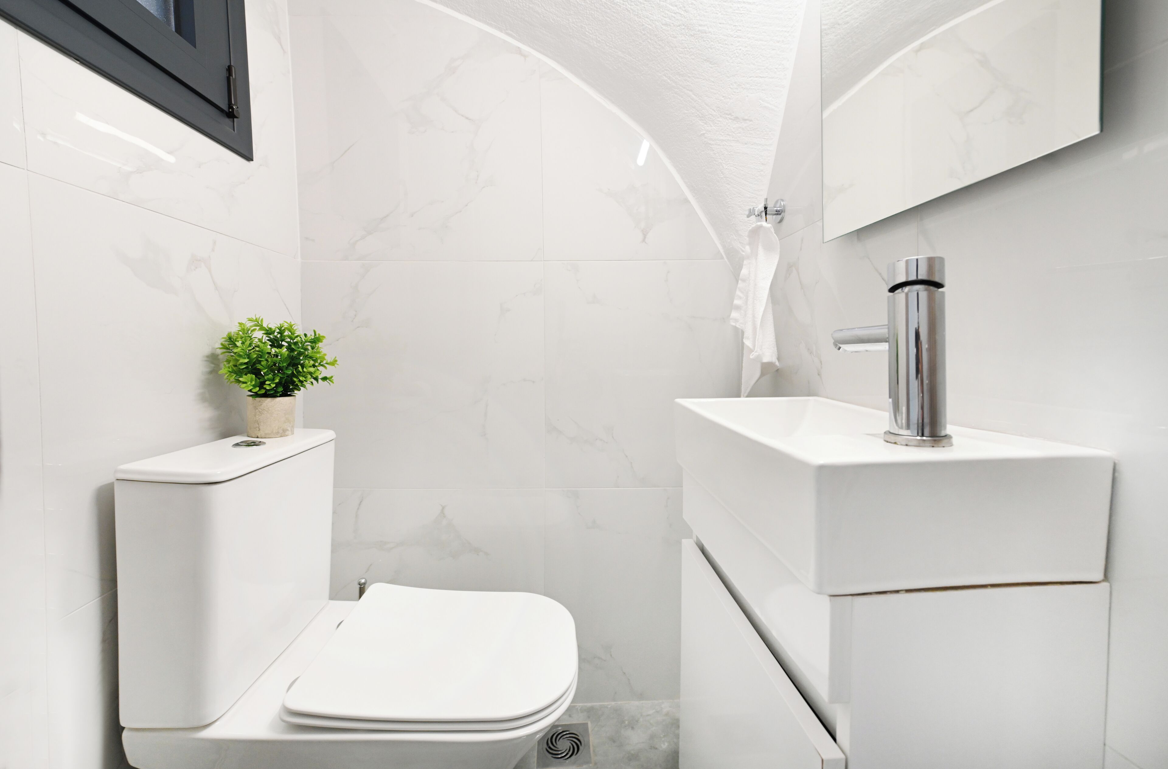 A modern bathroom with a toilet, sink, and shower.