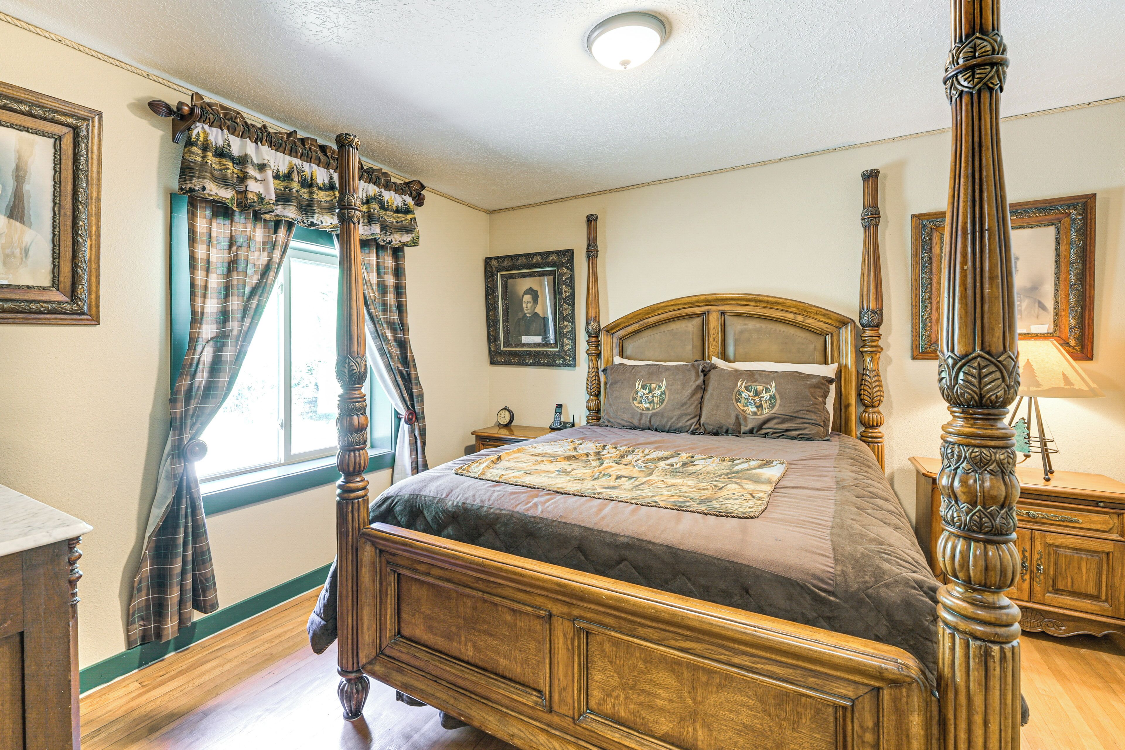 A four-poster bed with a headboard, a nightstand, and a bedside table with a lamp.