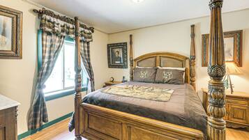 A four-poster bed with a headboard, a nightstand, and a bedside table with a lamp.
