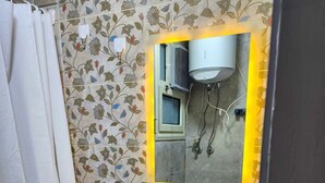 A bathroom with a floral-patterned wall, a white sink with a mirror above it, and a shower curtain. - 2 BRs Urban Oasis: Airport & Metro (Cairo Governorate)