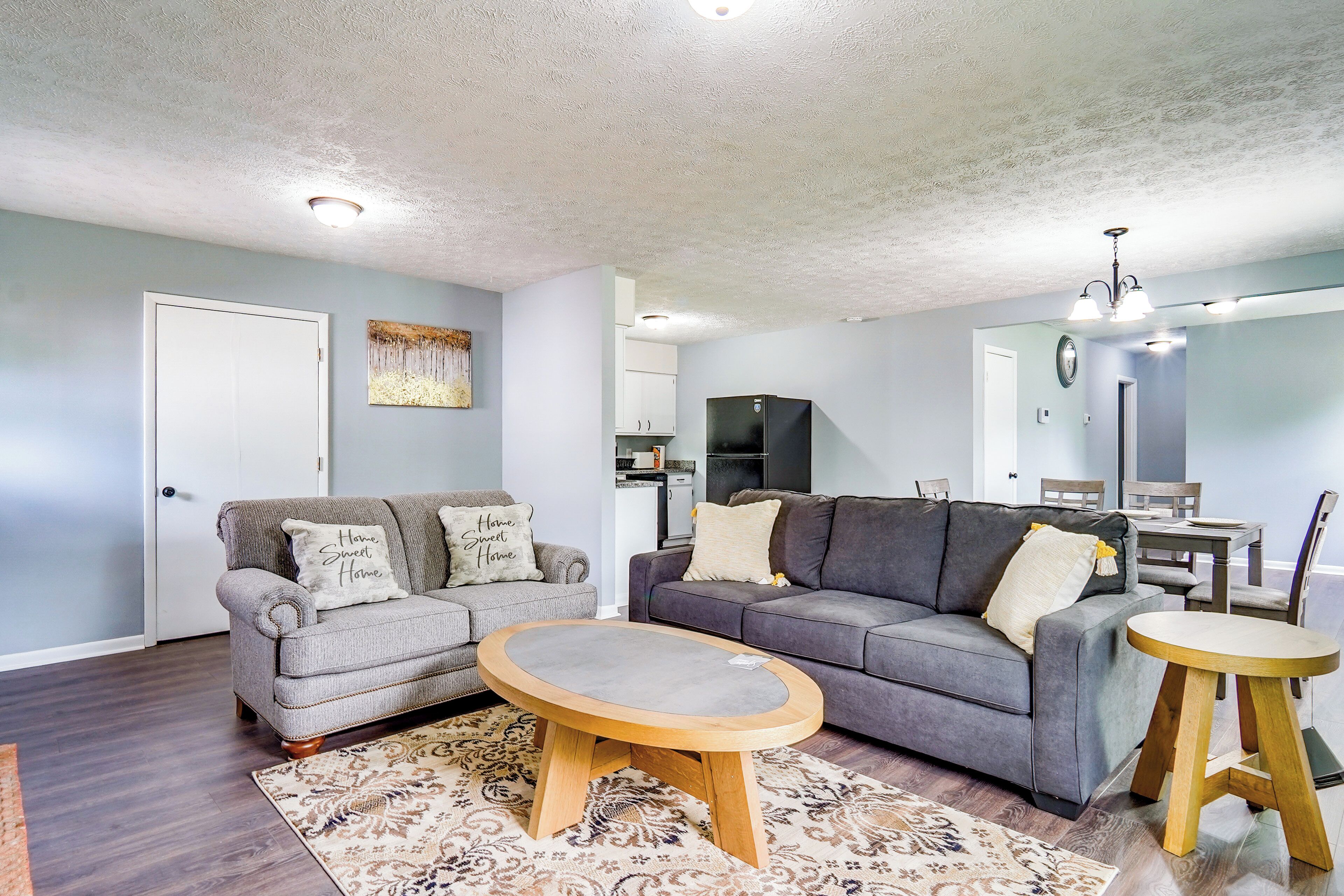 A living room with two sofas, a coffee table, and a dining table.