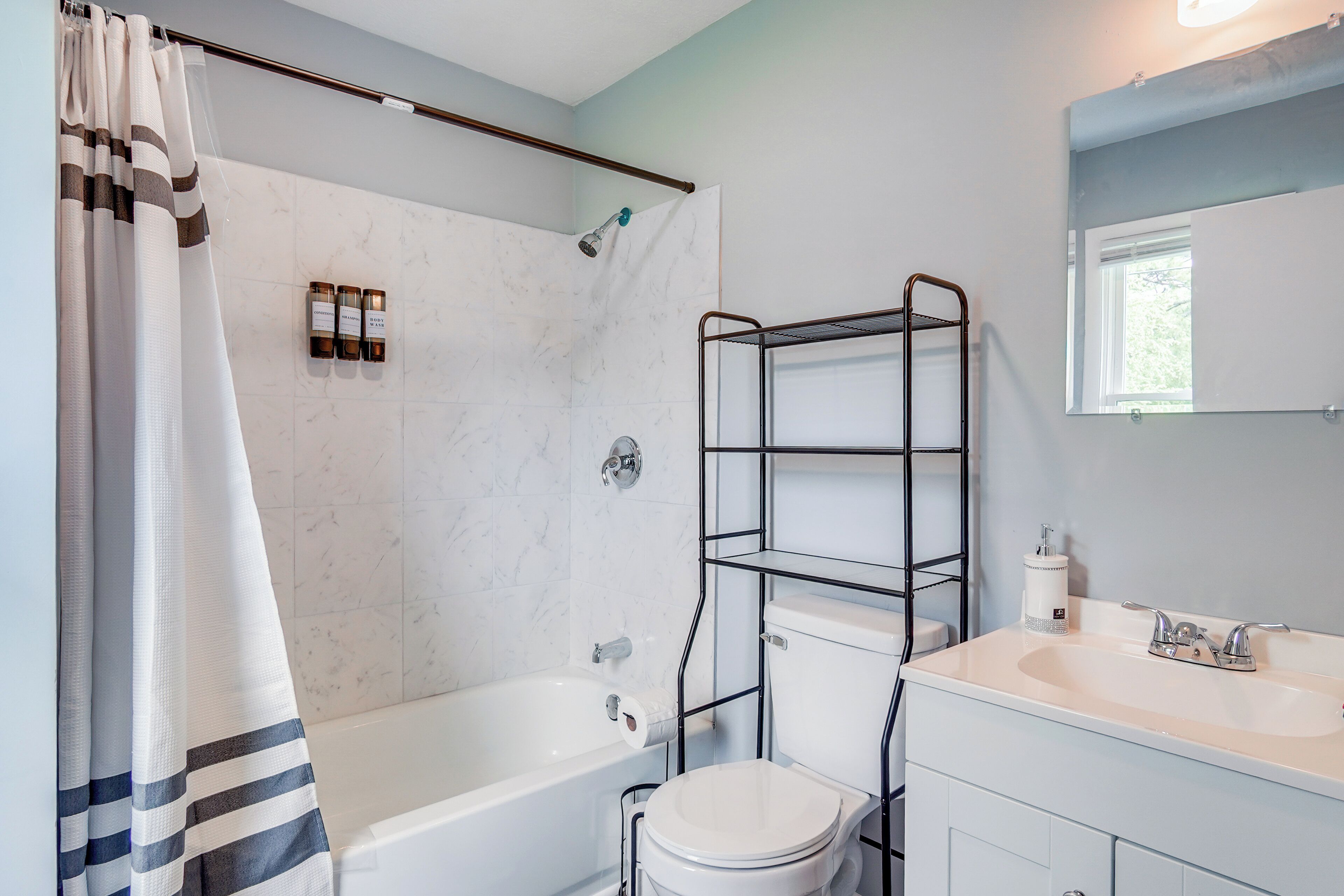 Een badkamer met een bad, toilet en een schapunit.