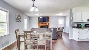 A spacious living area with a dining table, chairs, a sofa, and a kitchen area with cabinets and a countertop. - 5 Mi to Dtwn: Family-friendly Fayetteville Home! (Fayetteville)