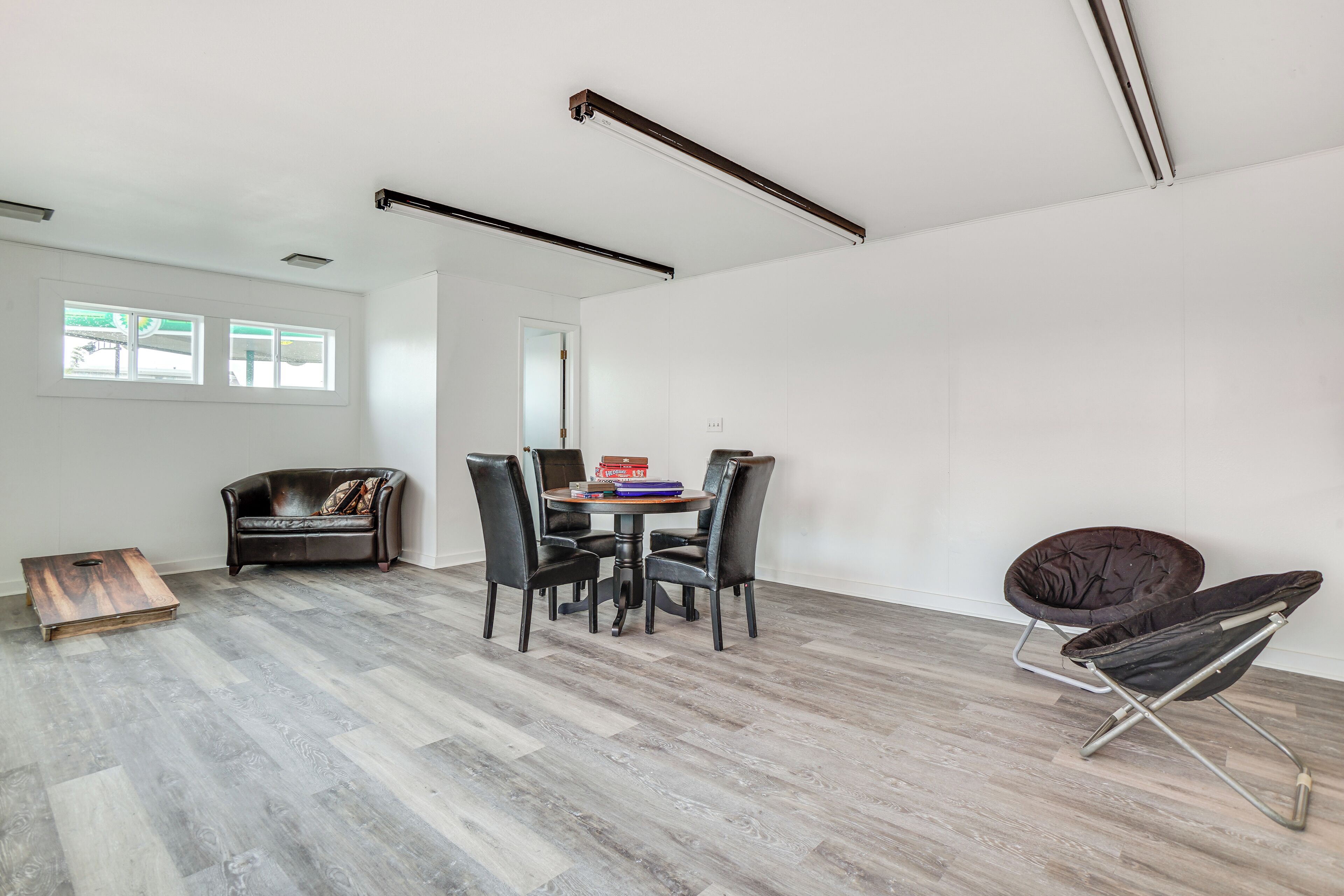 A modern living room with a dining area, featuring a sofa, chairs, a coffee table, and a unique floor lamp.