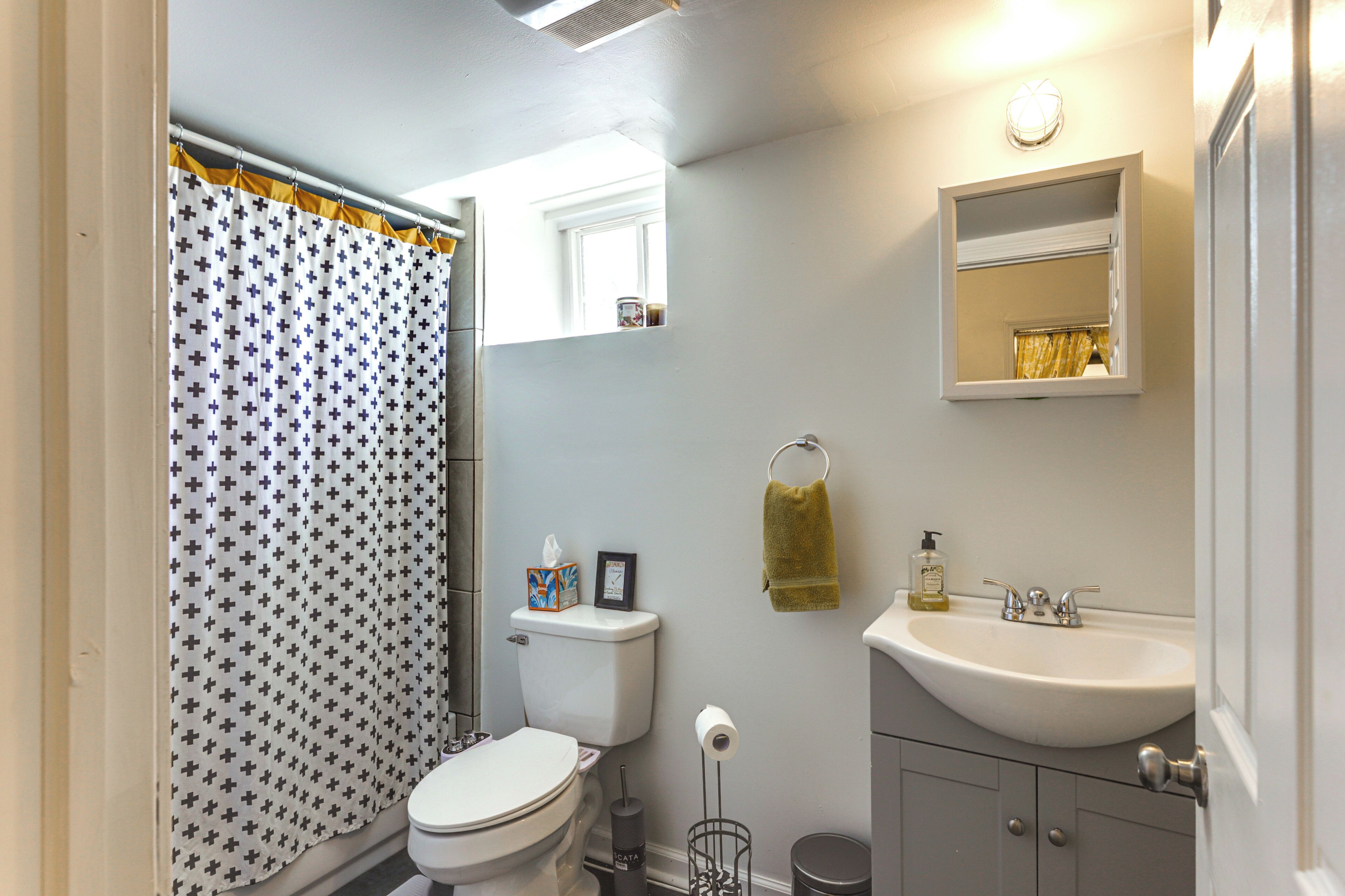 Een badkamer met toilet, wastafel en douchegordijn.