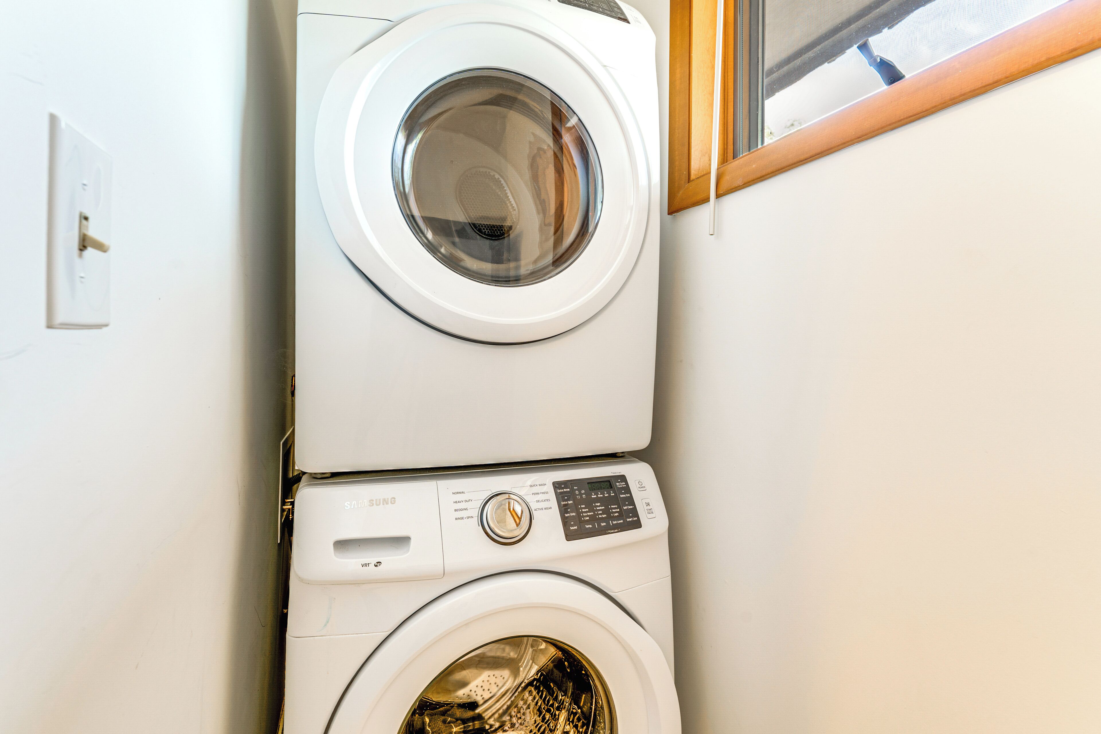 A stacked washer and dryer unit in a room.