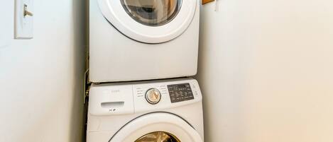 A stacked washer and dryer unit in a room.