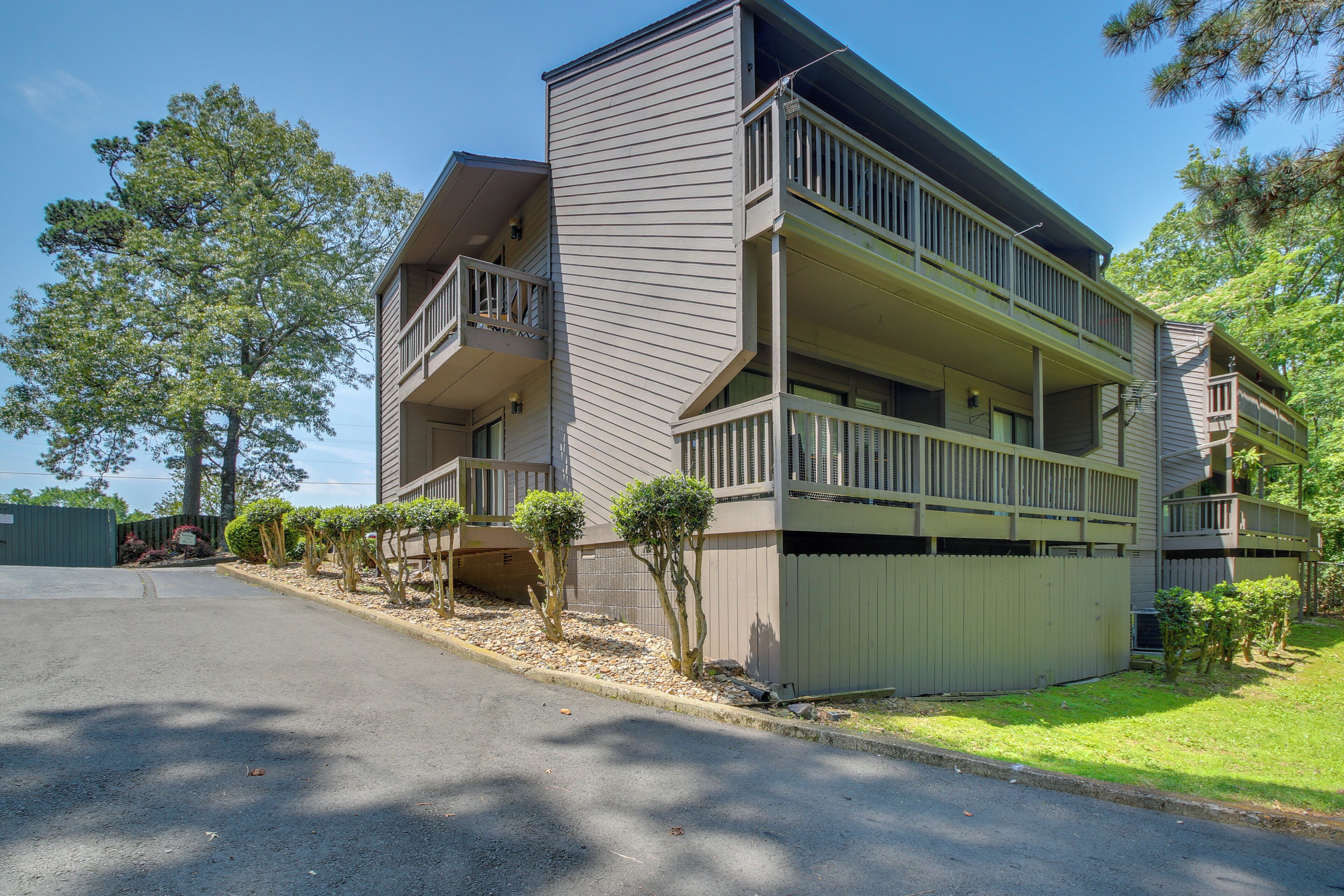 A multi-story residential building with balconies, a garage, and a well-maintained lawn.