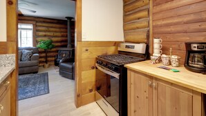 A compact kitchen with a stove, coffee maker, and a small dining area. - Hike, Bike & Explore: Woodsy Retreat in Mt Laguna! (Mount Laguna)