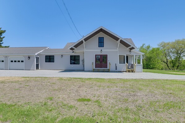 A two-story house with a front porch, a garage, and a covered driveway.