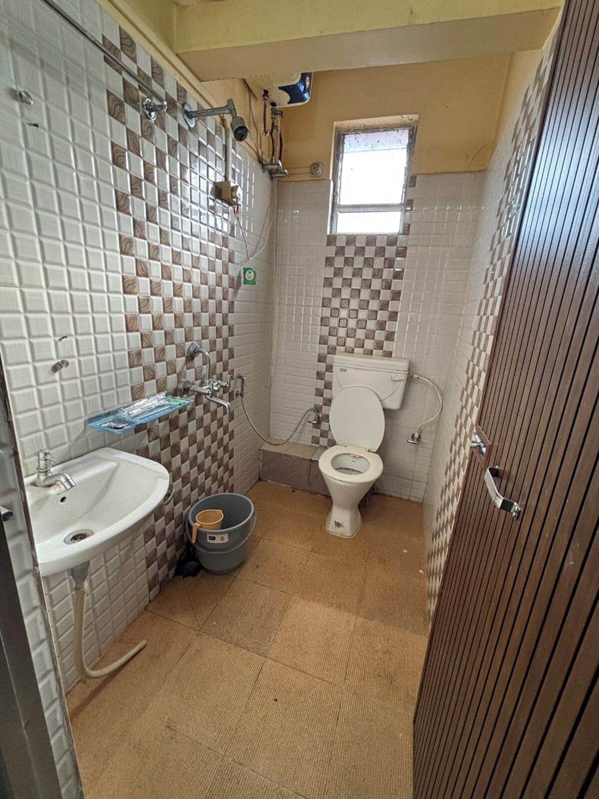 Une petite salle de bain avec des toilettes, un lavabo et une douche.