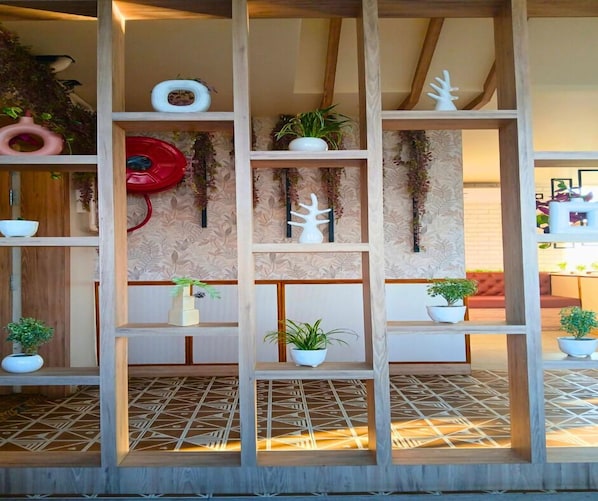 Une étagère en bois ornée de plantes en pot et d’objets décoratifs.