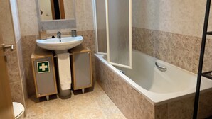Une salle de bain avec un lavabo, un miroir et une baignoire.