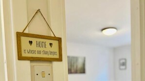 Une chambre à coucher avec un lit, une table de chevet et un interrupteur fixé au mur.
