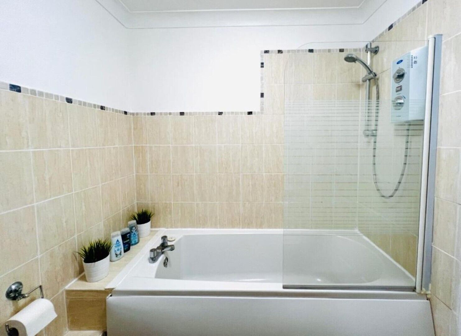 Ein modernes Badezimmer mit Badewanne, Glasdusche und Toilette.