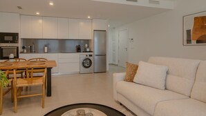 A modern apartment with a dining area, kitchenette, and living room. - Chic Coastal Living on the New Golden Mile (Estepona)