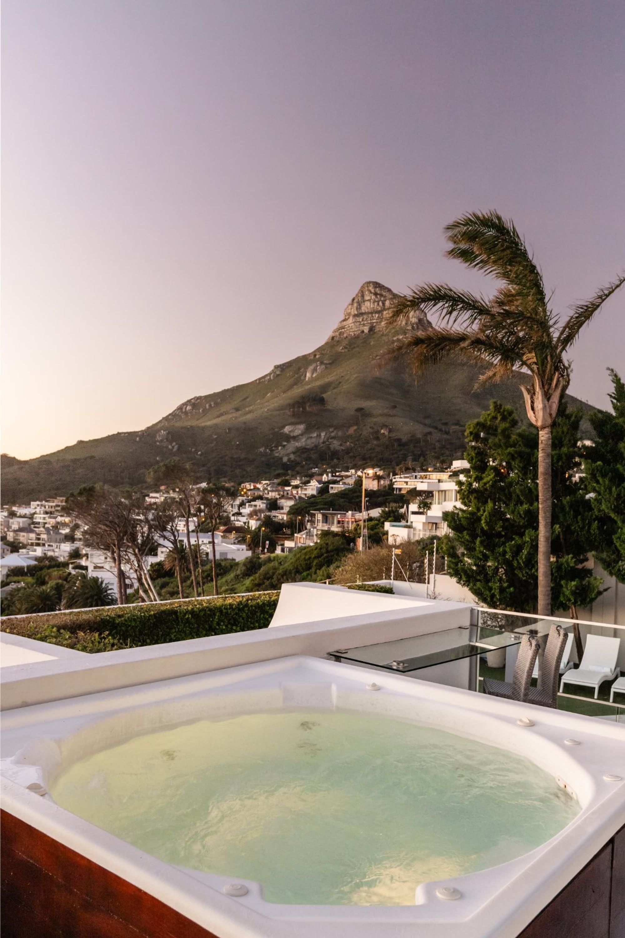 A hot tub with a view of a mountain and a residential area.