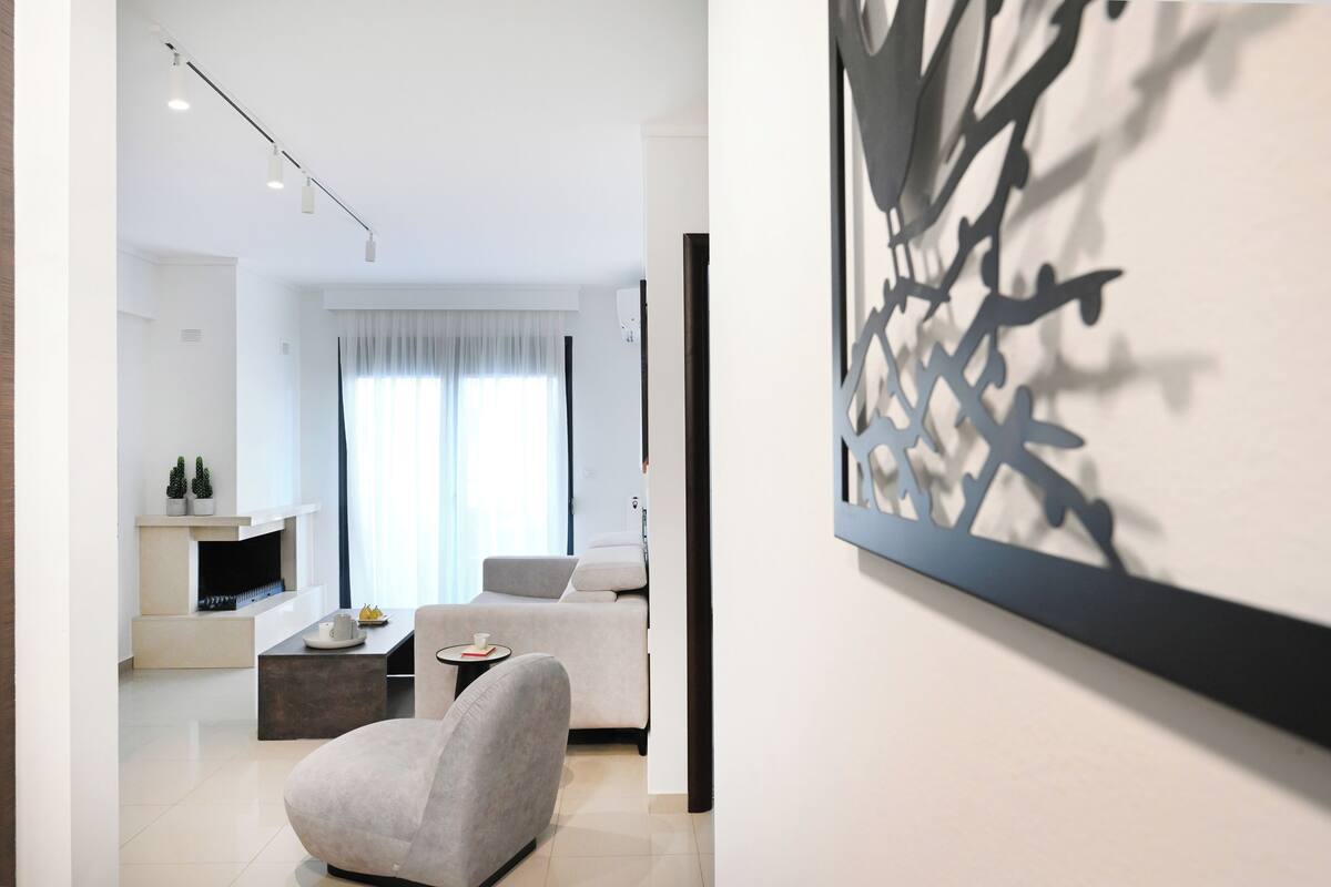 A modern living room with a sofa, a coffee table, and a fireplace.