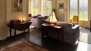 Ein geräumiges Wohnzimmer mit großem Fenster, Kamin und gemütlicher Sitzecke.