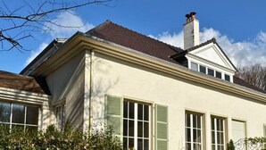 Ein zweigeschossiges Haus mit Satteldach, Dachgauben und Schornstein.