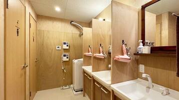 Un baño moderno con paredes de madera, dos lavamanos, un espejo grande y una zona de ducha.