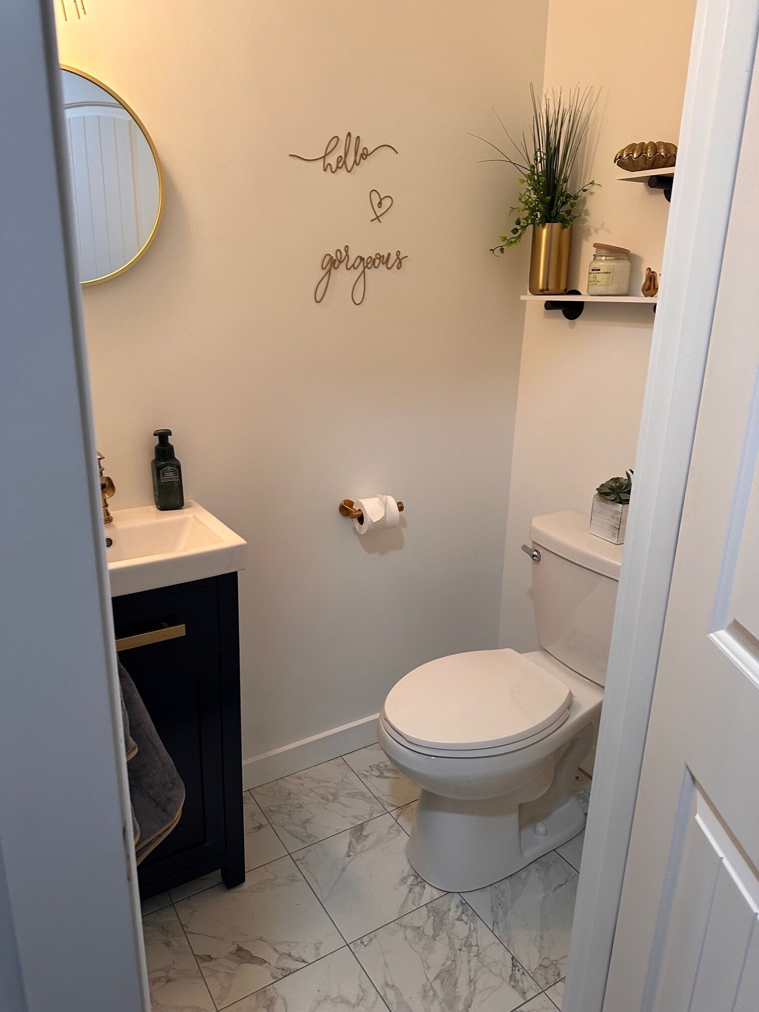 A bathroom with a toilet, sink, and a wall-mounted mirror.