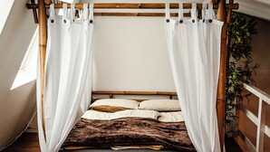 A bed with a canopy, white curtains, and a brown headboard. - Wellness for two (Ahlen)