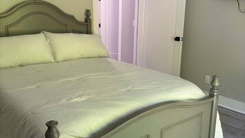 A bed with a headboard, a bedside table, and a wall-mounted TV.