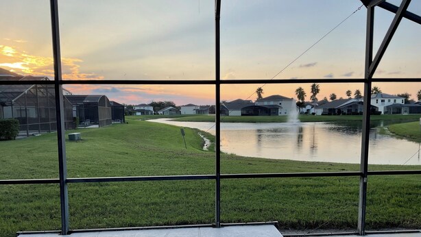 A swimming pool with a view of a residential area and a pond. - Charming 4-bedroom villa with WiFi, AC in wonderful Kissimmee (Kissimmee)