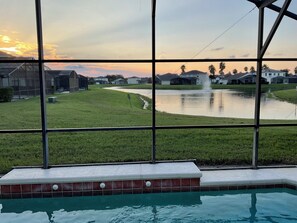 Una piscina con vistas a una zona residencial y un estanque.
