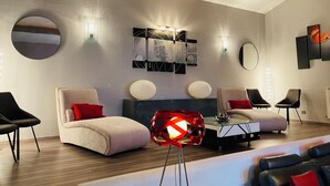 A modern living room with a sofa set, a coffee table, and a unique red spherical lamp. - Bastide desRomarins (Cavaillon)