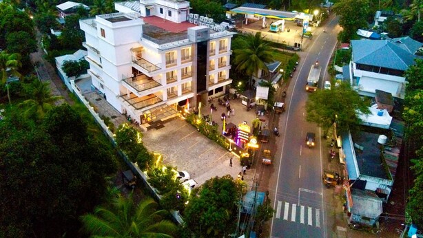 Un hôtel à plusieurs étages doté d’une terrasse sur le toit, d’une station-service et donnant sur la rue.