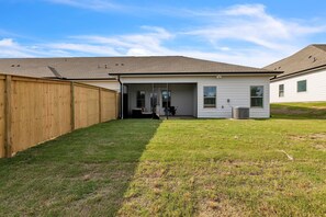 A single-story house with a covered patio and a fenced backyard. - Modern Nest - Huntsville Hideaway 3 Bedroom Home (Huntsville)