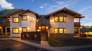A two-story building with a stone facade, multiple windows, and a central staircase. - Edelweiss Escape 1 Bedroom Condo (Leavenworth)