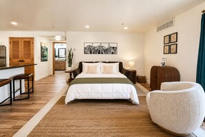 A bedroom with a bed, bedside tables, a chair, and artwork on the walls. - Edelweiss Escape 1 Bedroom Condo (Leavenworth)