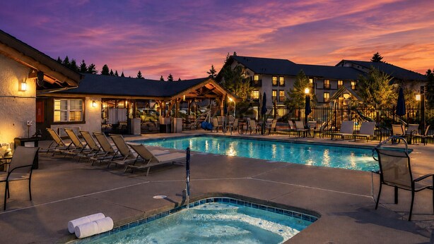 A hotel with a pool area, lounge chairs, and a hot tub. - Edelweiss Escape 1 Bedroom Condo (Leavenworth)