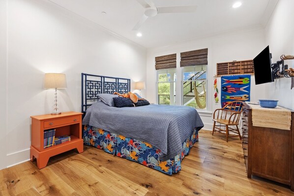 A bedroom with a bed, a nightstand, a bookshelf, a desk, and a chair. - Cornfed Pelican 9 Bedroom Home (Georgetown)