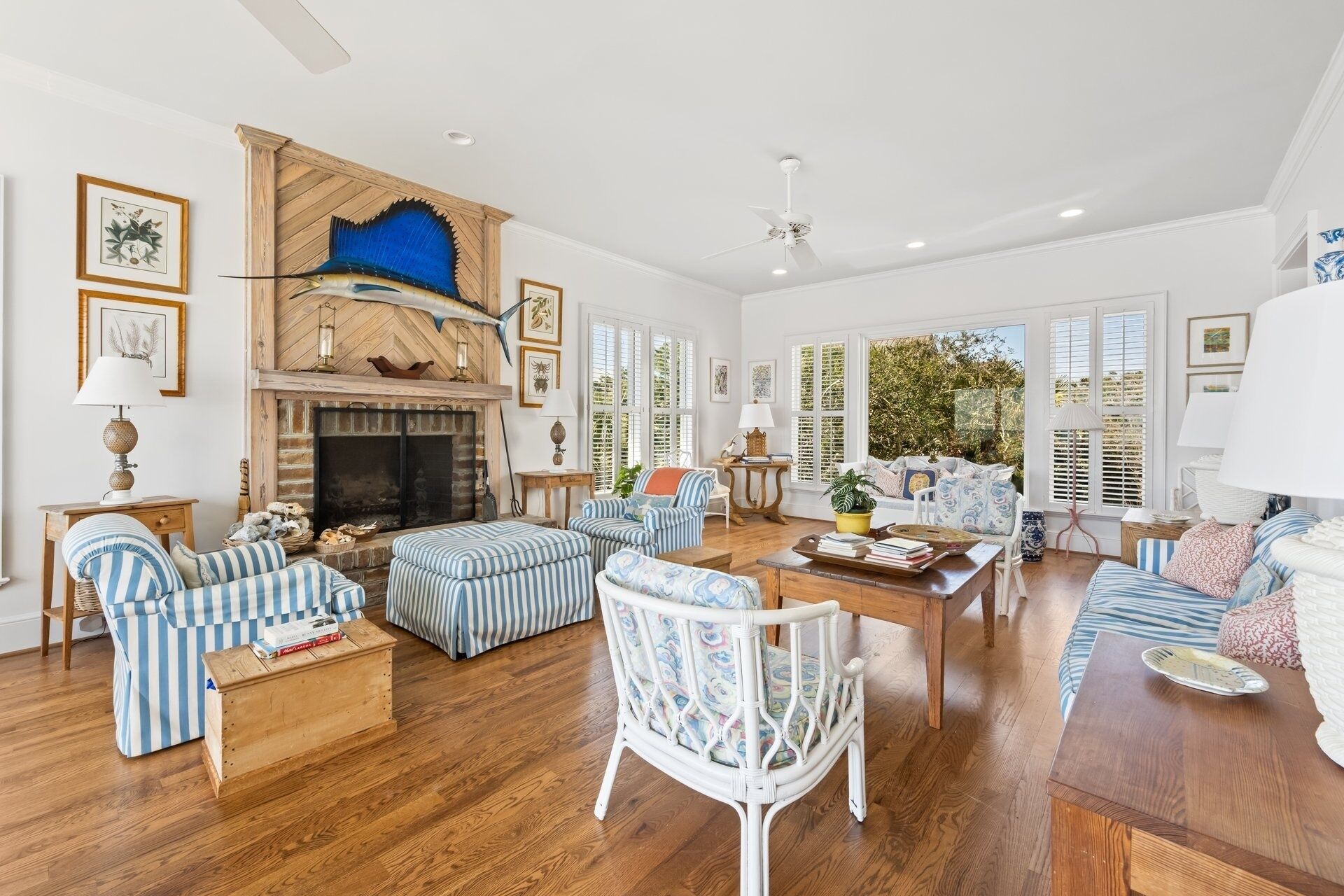 A spacious living room with a fireplace, striped sofas, and a wooden coffee table.