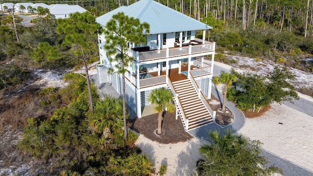A two-story beachfront house with a covered porch and a staircase leading to the entrance. - ☀️Steps to Beach | Great Decks | Golf Cart Included | Home Away From Home☀️ (Port St Joe)