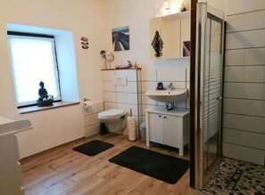 Ein Badezimmer mit Toilette, Waschbecken und Fenster.