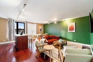 A modern living room with a sofa, chairs, a coffee table, and a dining area.