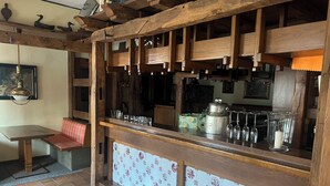 Un área de bar rústica con vigas de madera, salpicadero de azulejos y un banco.