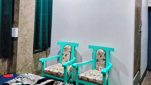 Ein Badezimmer mit zwei türkisfarbenen Stühlen, einem Deckenventilator und Wandbildern mit Schmetterlingen.