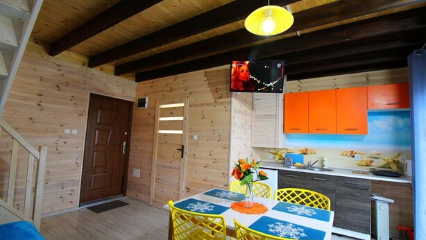 Een houten interieur met een eethoek, keuken en een deur.